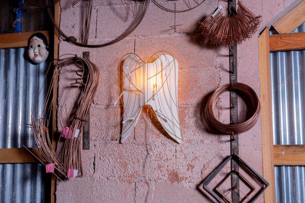 Vue de profil de l'applique moyen format allumée avec coupons du luminaire "Parle à ton ange" de l'Atelier Jour de Lune